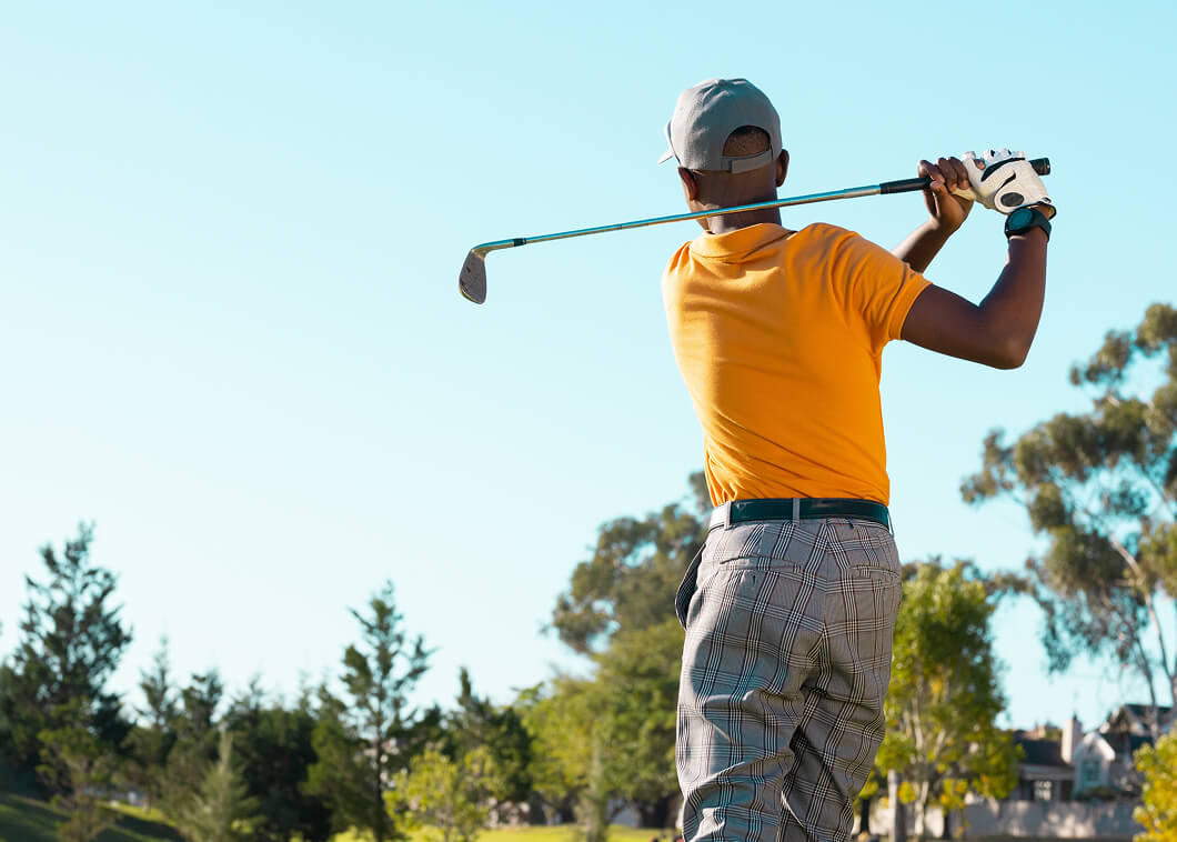 The back of a golfer just after a large swing
