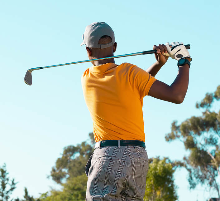 The back of a golfer just after a large swing