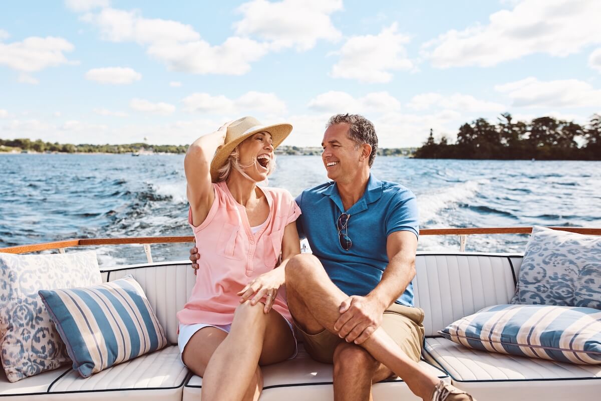 Happy couple laughs as they enjoy a boat ride