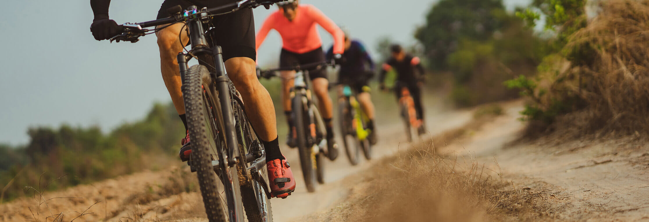 Cyclists riding down a dirt road