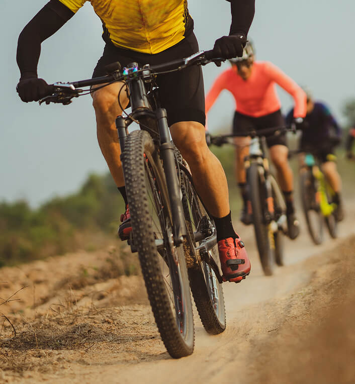 Cyclists riding down a dirt road