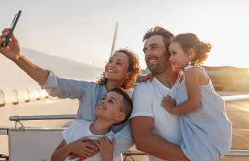 Family taking a selfie near an airplane