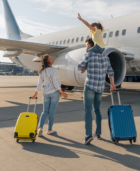 Family with luggage near an airplane