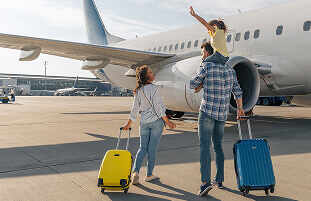 Family with luggage near an airplane