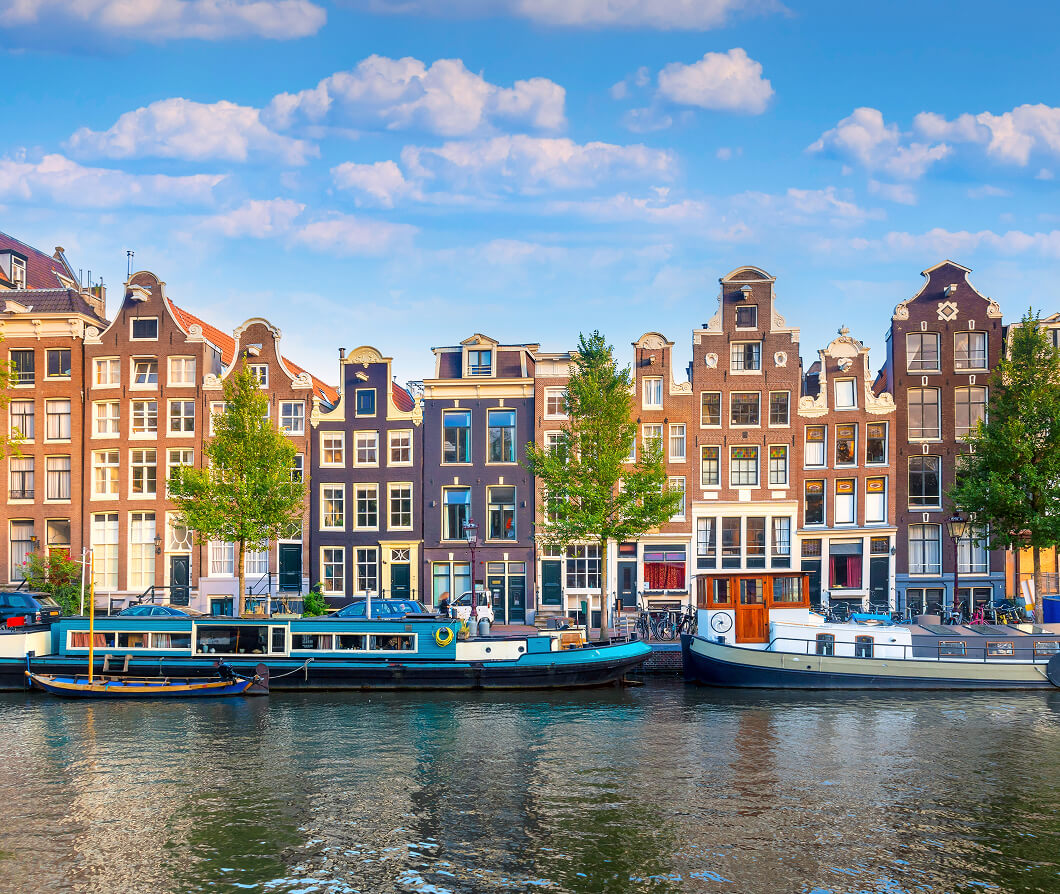Houseboats docked on a river next to an array of buildings