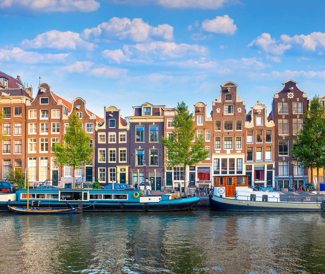 Houseboats docked on a river next to an array of buildings
