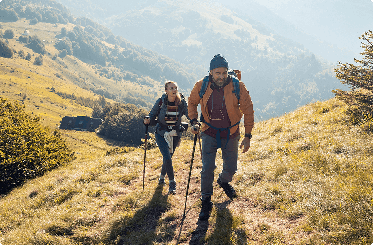 An active man and woman hike through fog hills somewhere in Europe