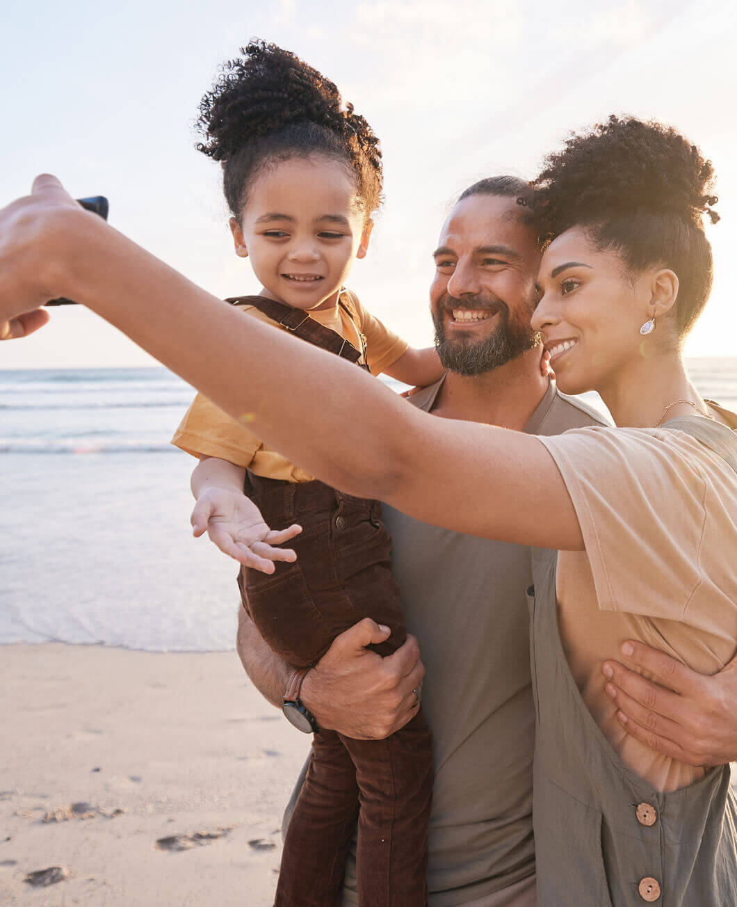 A family taking a selfie together on the beach.