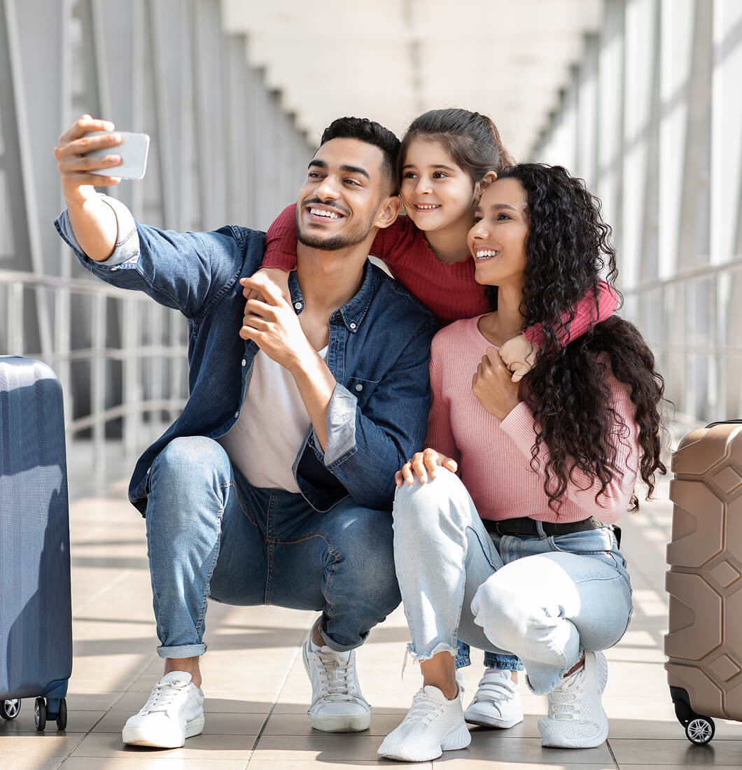A family taking a selfie in the hallway of an airport.