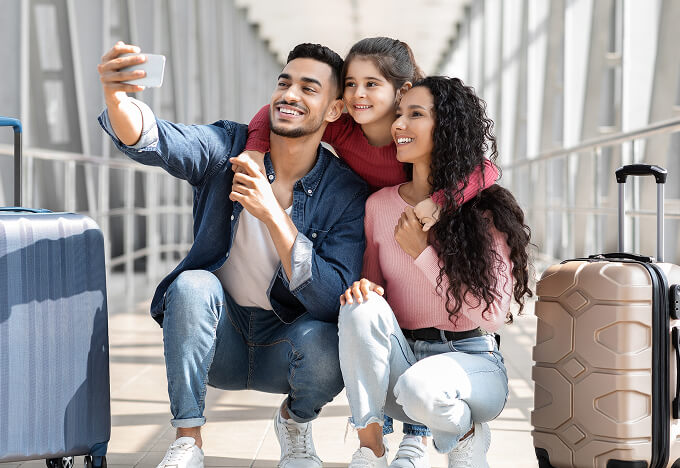 A family taking a selfie in the hallway of an airport.