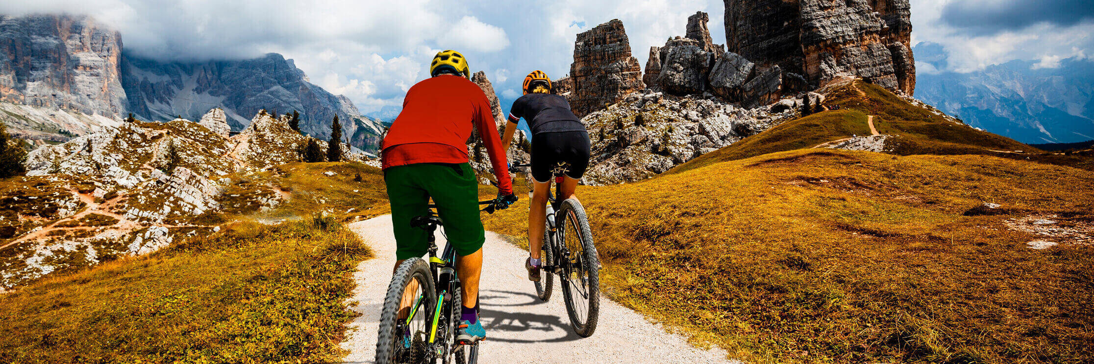 people riding mountain bikes down a path