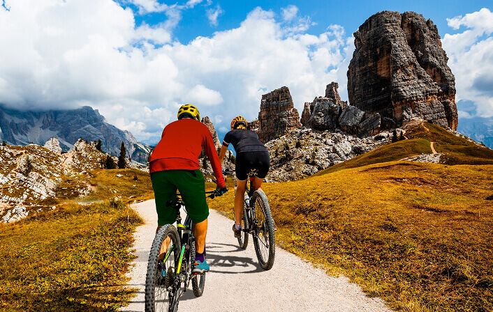 people riding mountain bikes down a path