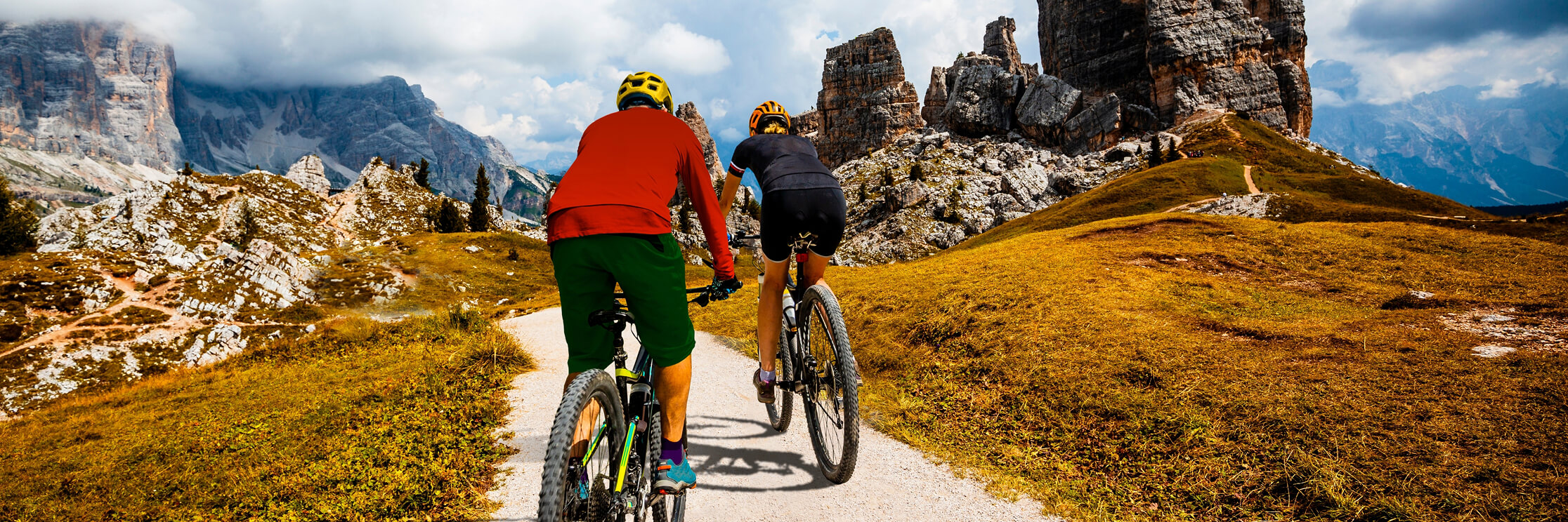people riding mountain bikes down a path