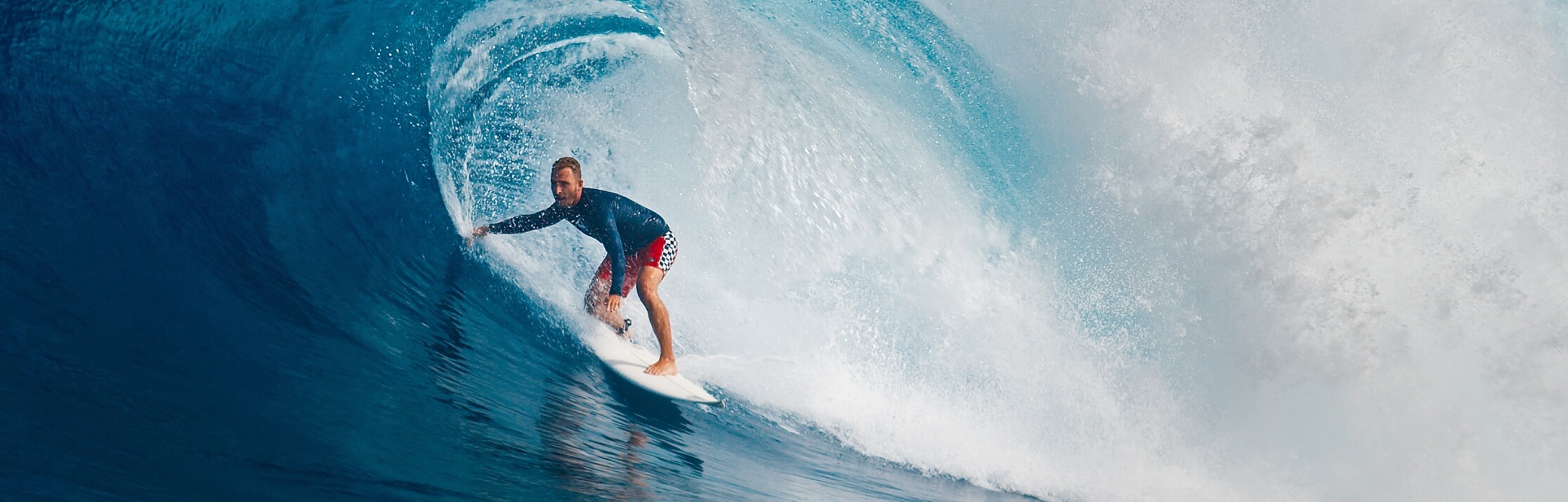 A male surfer riding a wave on a surfboard