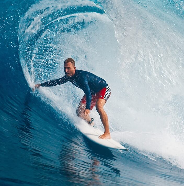 A male surfer riding a wave on a surfboard